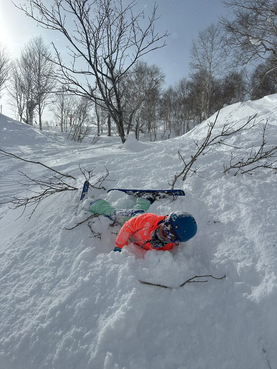 A skier face down in deep snow after a fall